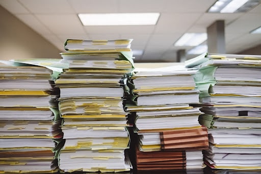 5 Reasons Why Your Garage Needs a Management System; A pile of paperwork in an office