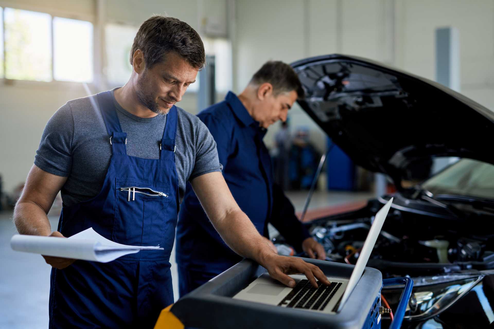 improve workshop performance; a mechanic working on a laptop