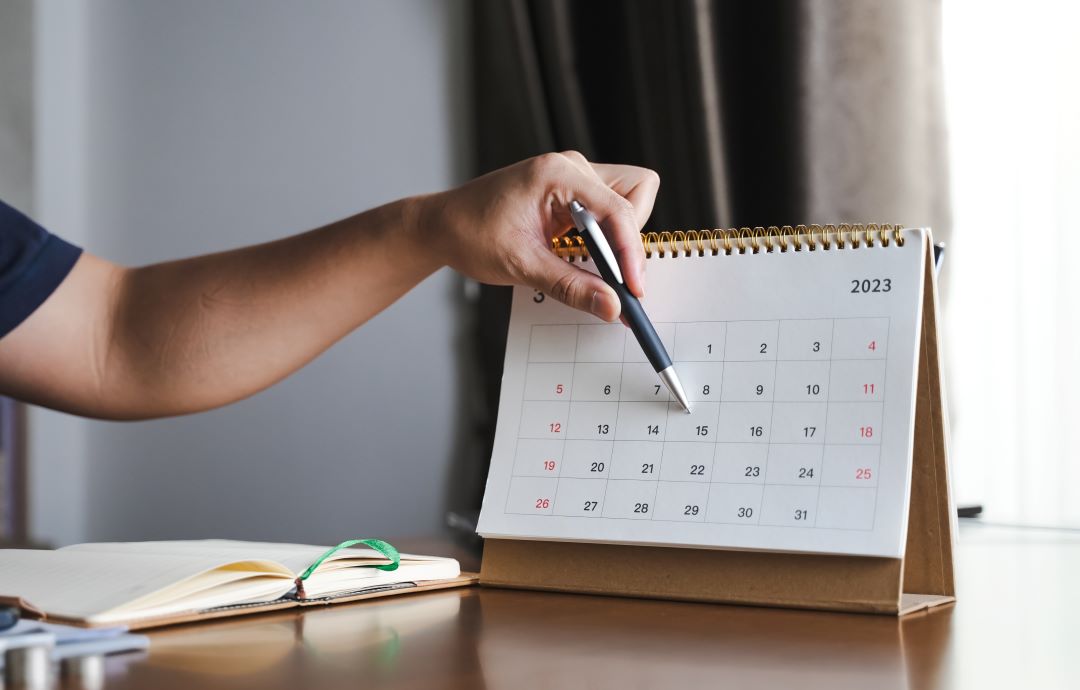 garage booking, a person pointing at a calendar with a pen