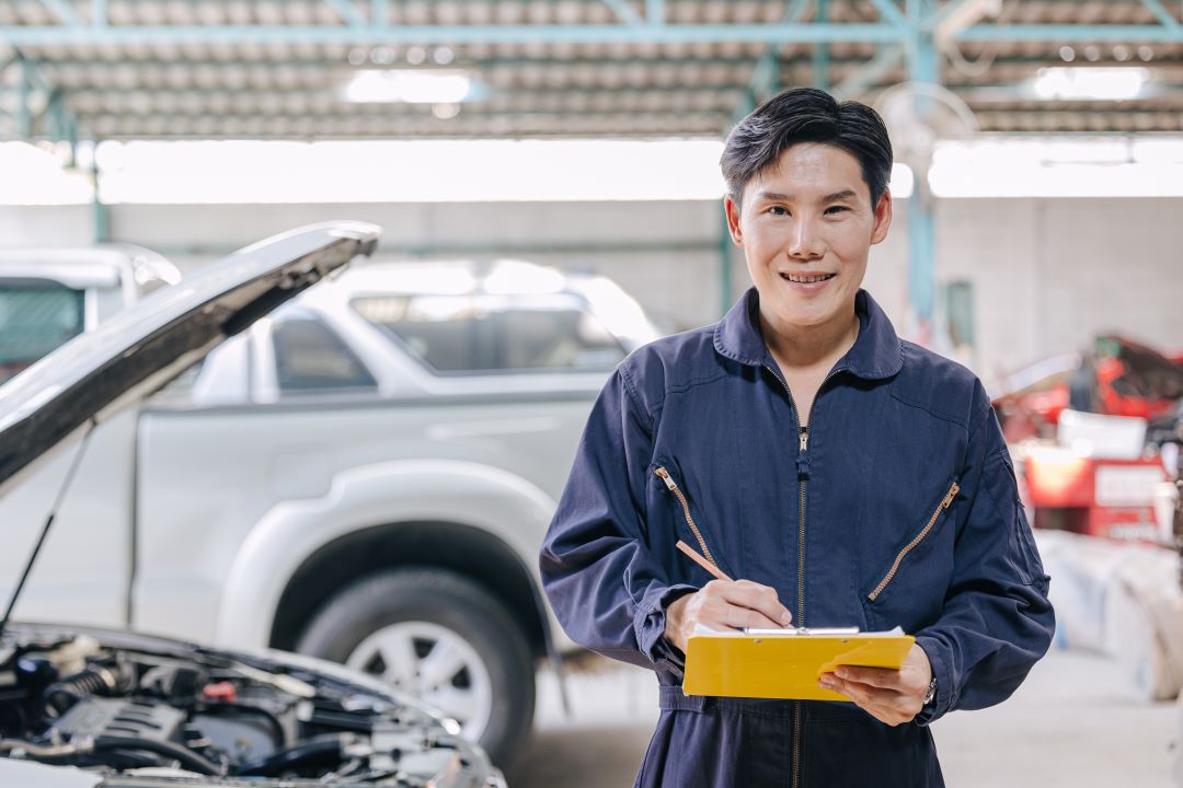 business branding, a car technician holding a notepad and smiling