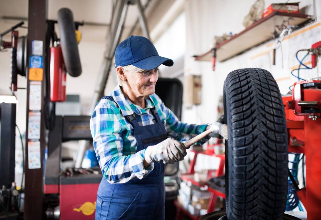 car garage, a car technician working on a tyre