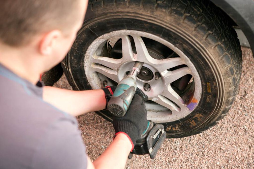 a car service technician working on a tyre
