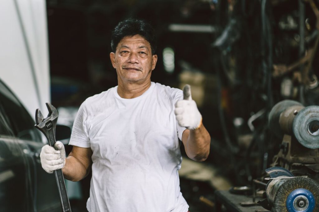 boost employee productivity, a car technician posing with a thumbs-up