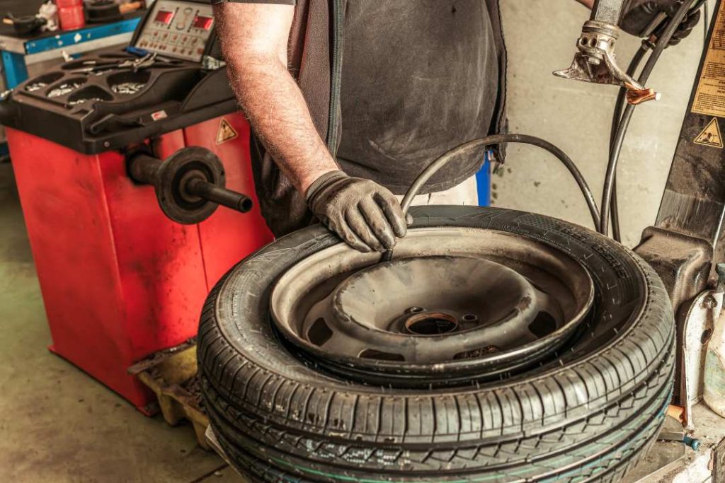 winter car tyre, a garage technician inspecting a tyre
