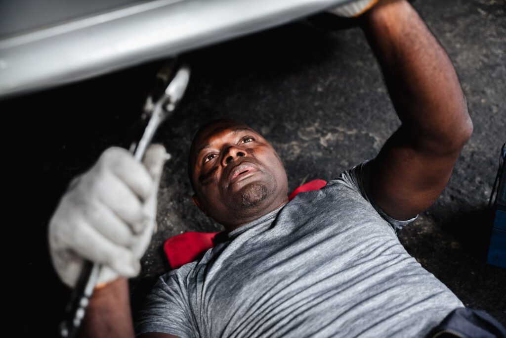 garage business, a car technician working on the undercarriage
