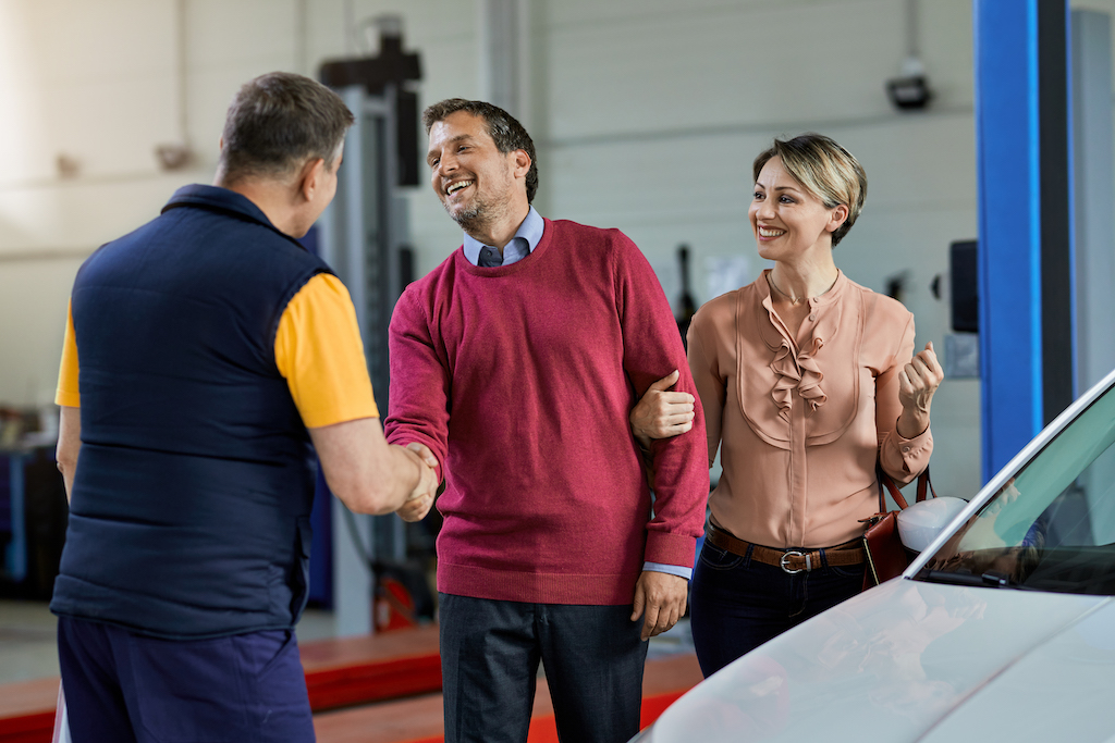 Garage customer feedback, garage mechanic talking to a couple.