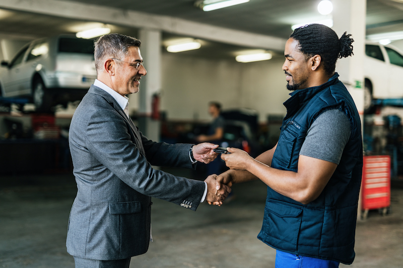 Garage customer feedback, garage mechanic shaking hands with a customer.