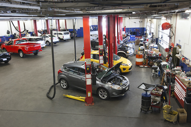 Busy garage, multiple cars in a garage.