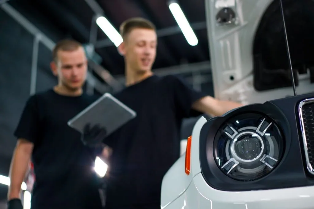 boost garage sales, two mechanics diagnosing a vehicle with the help of a tablet