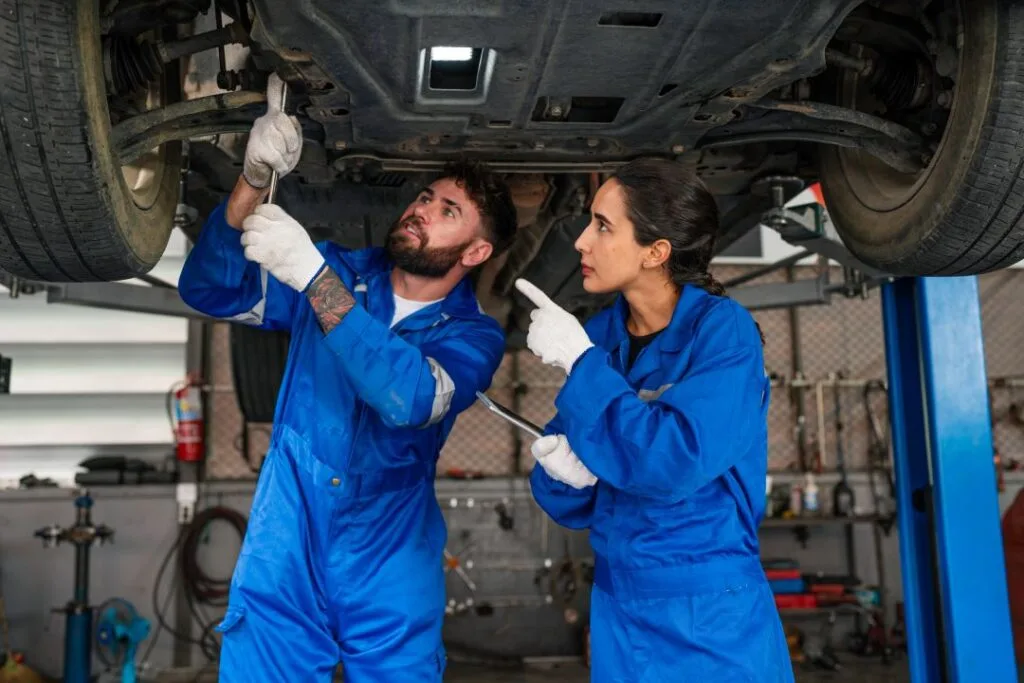 car garage profit, mechanics training a newbie on how to repair vehicle parts
