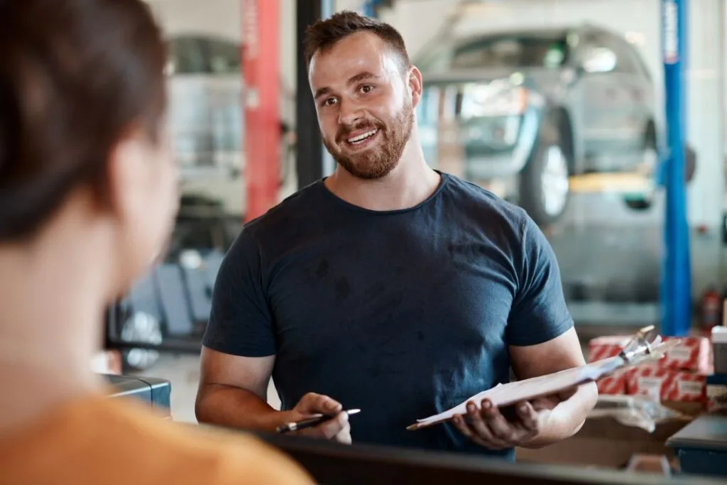 customer focused business, mechanic interacting with a customer with a smile on their face